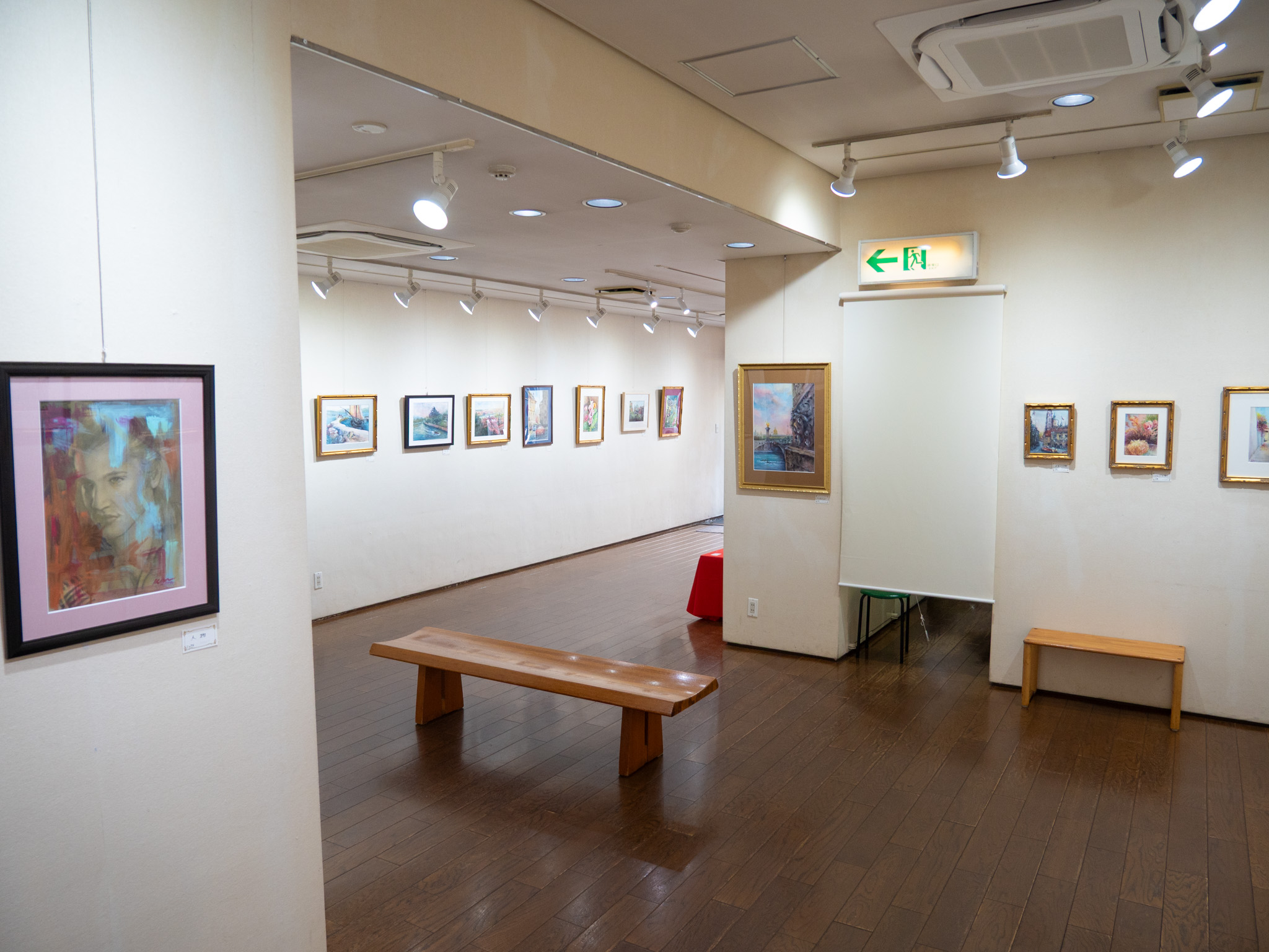 小原けい子展の会場。額装された風景画と花の作品が白い壁に並ぶ